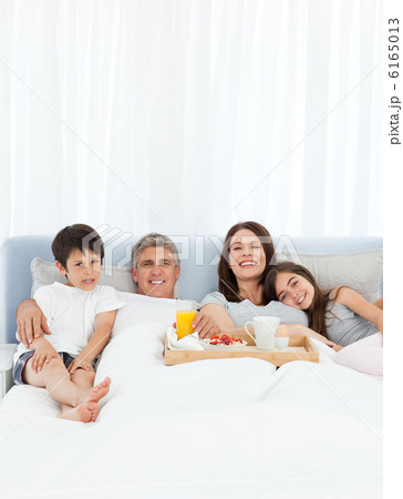 Family having breakfast in their bed Family having breakfast in their bed 6165013