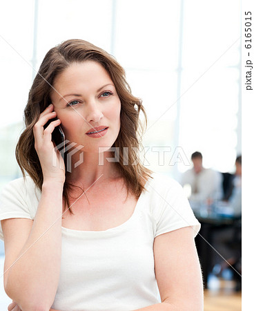 Pensive businesswoman on the phone while her team is working Pensive businesswoman on the phone while her team is working 6165015