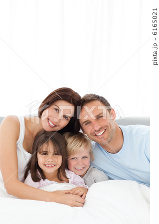 Portrait of a joyful family sitting on the bed Portrait of a joyful family sitting on the bed 6165021