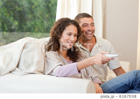 Couple watching tv in their living room at home Couple watching tv in their living room at home 6167038