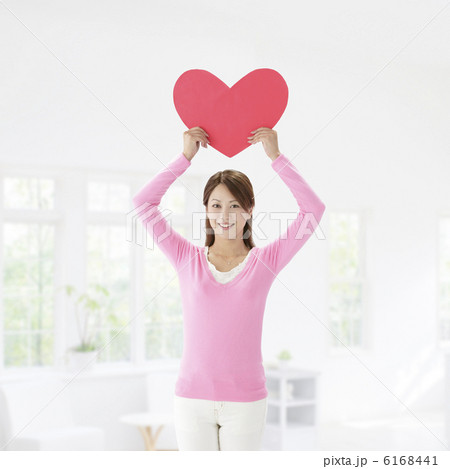 ハートのメッセージボードを持って立つ女性 6168441