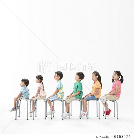 並んで椅子に座る子供達の写真素材