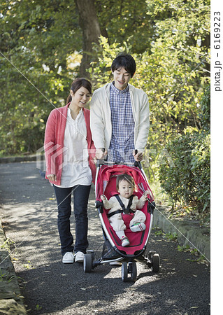 公園を散歩している赤ちゃんと若い両親 公園を散歩している赤ちゃんと若い両親 6169223
