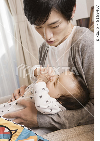 赤ちゃんをあやしている父親の写真素材