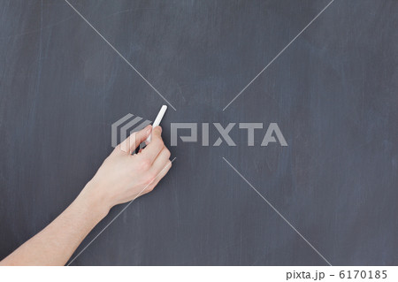 Hand holding a chalk and and ready to write on a blackboard 6170185