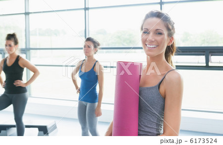 Woman holding a mat and two other women Woman holding a mat and two other women 6173524
