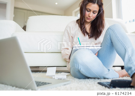 Woman sitting on the carpet and calculating bills Woman sitting on the carpet and calculating bills 6174234