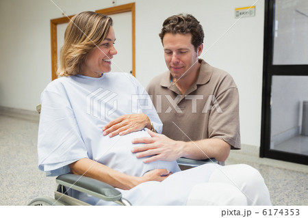 Pregnant woman and partner both touching her belly and smiling Pregnant woman and partner both touching her belly and smiling 6174353