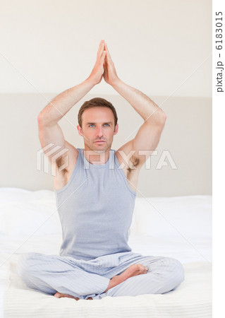 Man practicing yoga on his bed Man practicing yoga on his bed 6183015