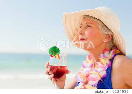 Woman drinking a cocktail in her deck chair 6184955