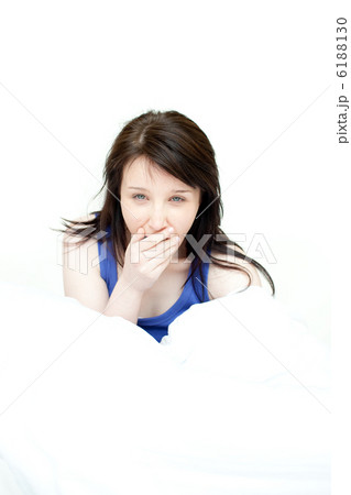 Radiant woman yawning sitting on her bed Radiant woman yawning sitting on her bed 6188130