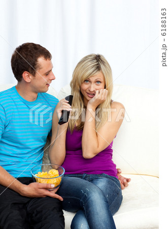 Couple watching television together on sofa Couple watching television together on sofa 6188163