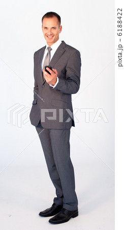Smiling businessman sending a message with a mobile phone Smiling businessman sending a message with a mobile phone 6188422