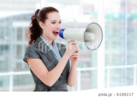 Self-assured businesswoman yelling through a megaphone Self-assured businesswoman yelling through a megaphone 6189217