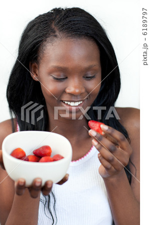 Cheerful Afro-american a woman eating strawberries 6189797