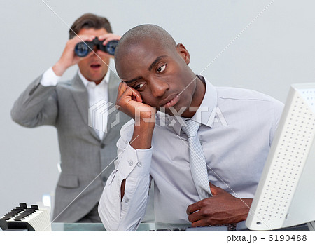 Afro-american businessman annoyed by a man looking through binoc 6190488