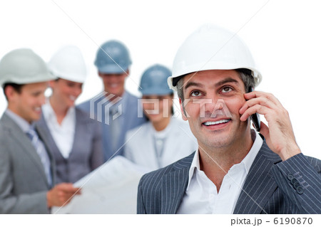 Confident male architect on phone in front of his team Confident male architect on phone in front of his team 6190870