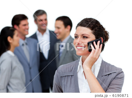 Caucasian woman talking on phone in front of her team Caucasian woman talking on phone in front of her team 6190871