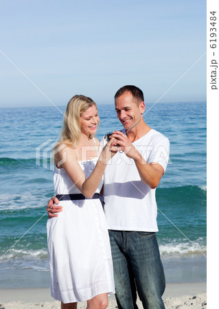 Happy couple looking at holiday photograph 6193484