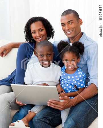 Smiling Afro-american family using a laptop Smiling Afro-american family using a laptop 6193652