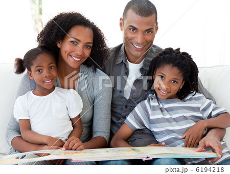 Portrait of an Afro-American family reading a book in the living Portrait of an Afro-American family reading a book in the living 6194218