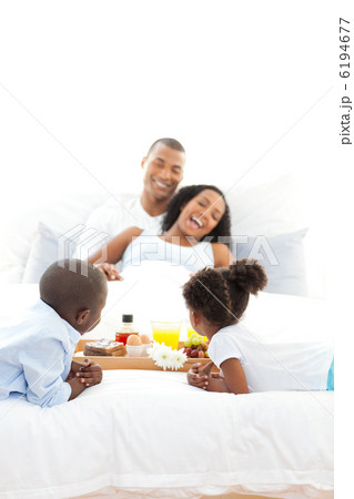 Cheerful family having breakfast in the bedroom 6194677