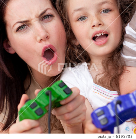 Excited mother and her daughter playing video games 6195703