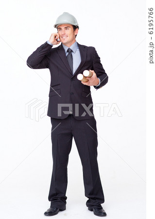 Attractive architect on mobile phone holding plans 6195766