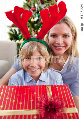 Happy mother and her son unpacking Christmas gift Happy mother and her son unpacking Christmas gift 6196004