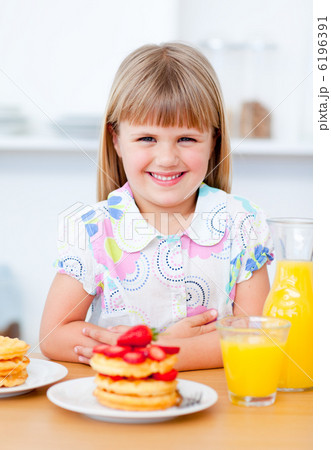 Joyful little girl eating waffles with strawberries Joyful little girl eating waffles with strawberries 6196391