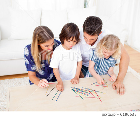 Loving family playing mikado in the living room Loving family playing mikado in the living room 6196635