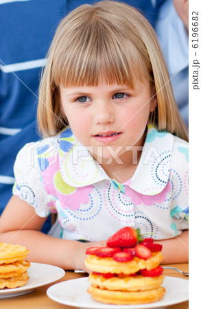 Cute little girl eating waffles with strawberries Cute little girl eating waffles with strawberries 6196682