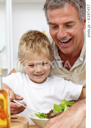 Happy grandfather eating a salad with grandson Happy grandfather eating a salad with grandson 6197457