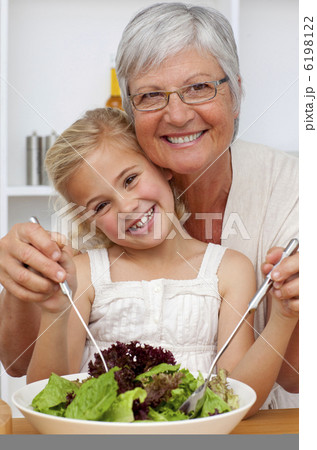 Happy grandmother eating a salad with granddaughter Happy grandmother eating a salad with granddaughter 6198122