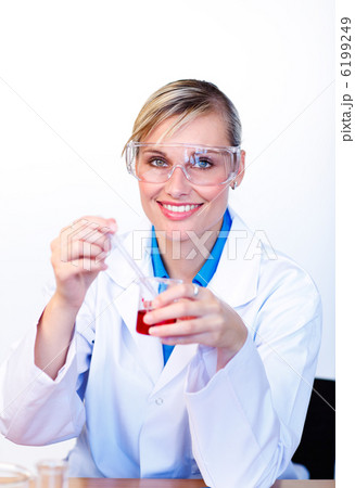 Female scientist examining a test-tube and smiling at the camera 6199249