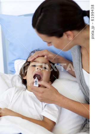 Close-up of mother taking her son's temperature with a thermomet 6199438