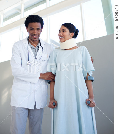 A doctor helping a patient with neck brace and on crutches A doctor helping a patient with neck brace and on crutches 6200713