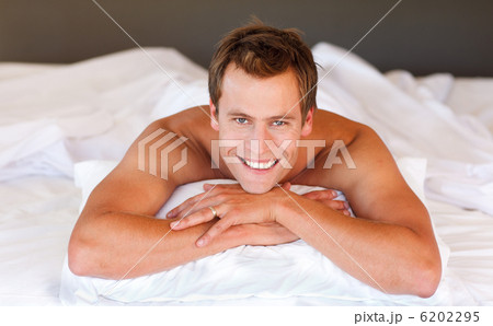 Attractive man smiling on bed 6202295