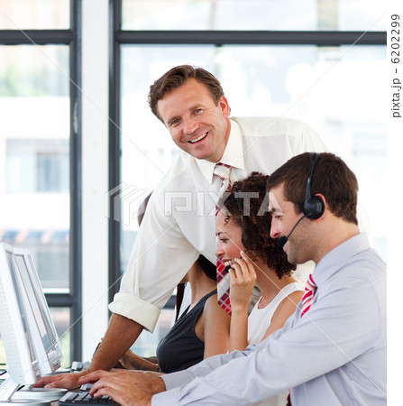 Mature manager in a call center smiling at the camera Mature manager in a call center smiling at the camera 6202299