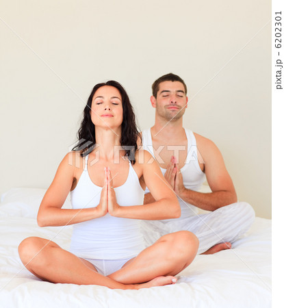 Couple doing yoga in bed Couple doing yoga in bed 6202301
