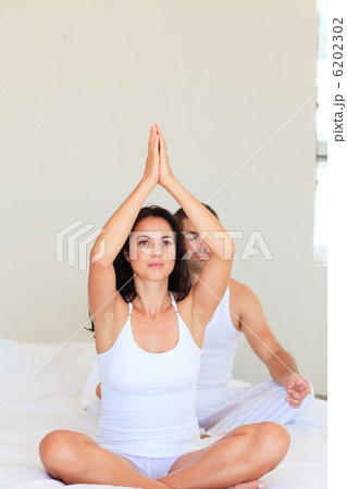 Couple practicing yoga in bed 6202302