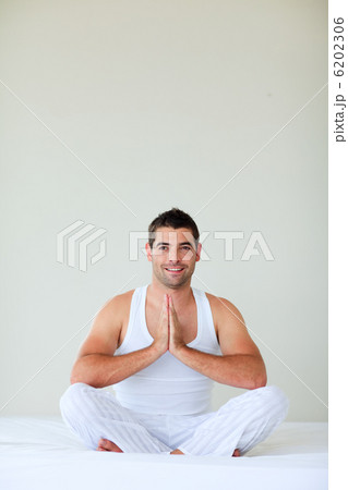 Young man meditating in bed with copy-space 6202306