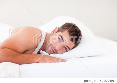 Handsome man lying in bed 6202709