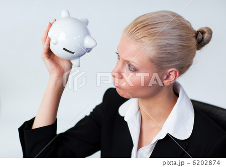 Sad Business woman looking into Piggy Bank 6202874
