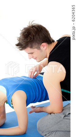 Caucasian woman working out assited by her personal trainer Caucasian woman working out assited by her personal trainer 6204365