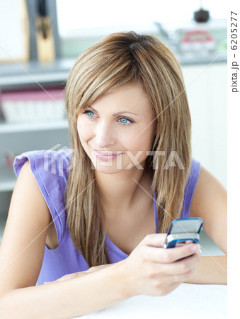 Delighted woman using a phone in the kitchen 6205277
