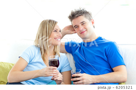 Cute couple drinking wine together in the living-room Cute couple drinking wine together in the living-room 6205321