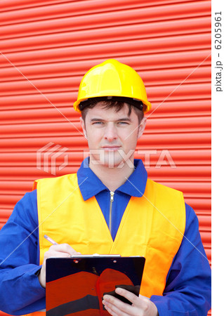 Confident worker writing on a clipboard 6205961