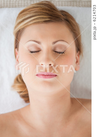 Young and pretty blond-haired woman lying down while receiving a 6214703