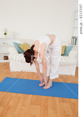 Pretty red-haired female stretching in the living room Pretty red-haired female stretching in the living room 6215597